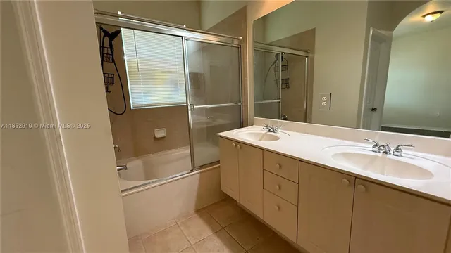 a bathroom with a double vanity sink a mirror and a shower