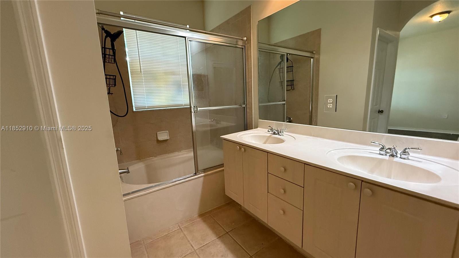 3361 Merrick Lane, Unit 808 Margate, FL 33063 - Photo 9 of 13 a bathroom with a double vanity sink a mirror and a shower