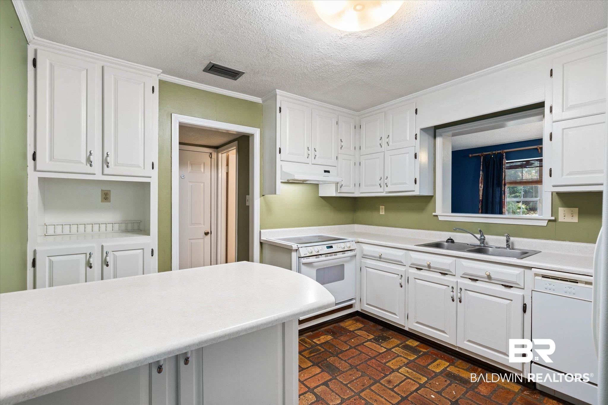 6632 Autumn Ridge Drive Mobile, AL 36695 - Photo 7 of 22 Kitchen featuring brick patterned flooring, white appliances, white cabinetry, a textured ceiling, and light countertops