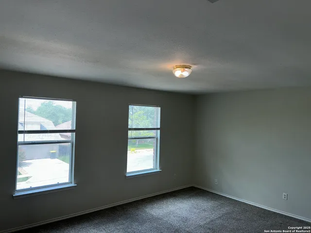 a view of a kitchen with a sink stove cabinets and empty room