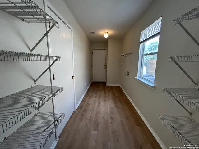 a view of a big room with wooden floor and windows