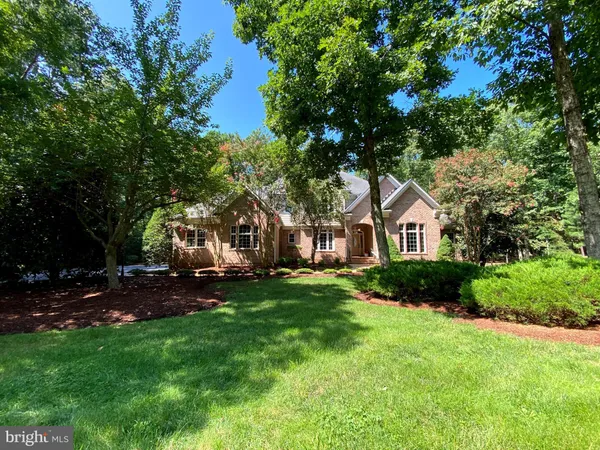 a front view of a house with a yard and trees