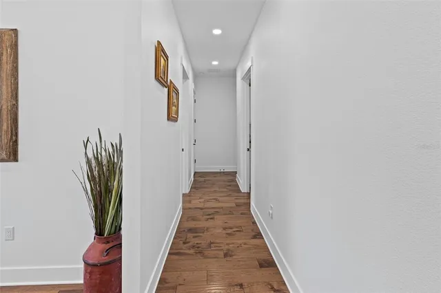 a view of a hallway with wooden floor and stairs