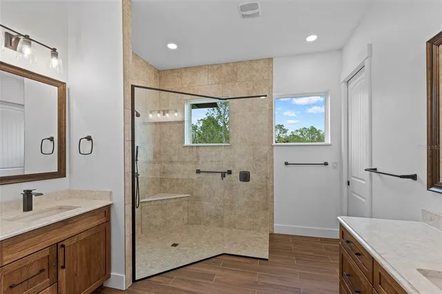a bathroom with a granite countertop sink a mirror and shower