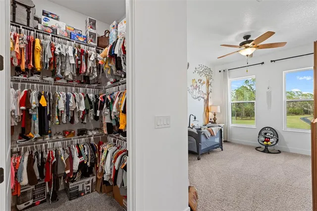 a view of walk in closet with clothes and shoes