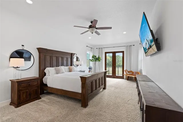 a spacious bedroom with a bed and a chandelier