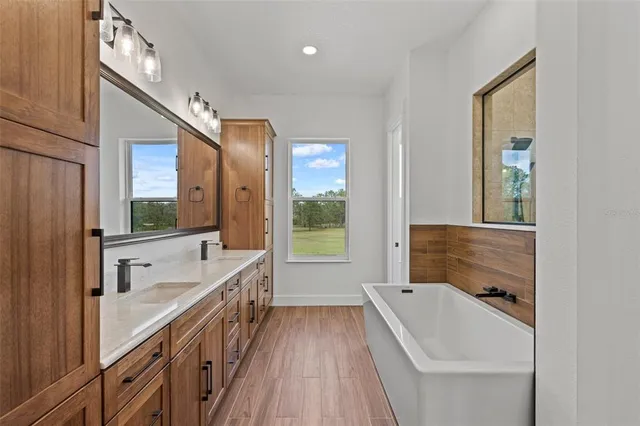 a bathroom with a granite countertop tub sink a mirror and a bathtub
