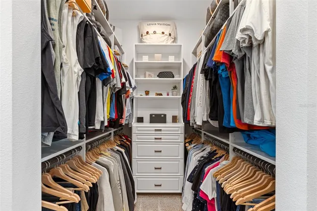 a view of walk in closet with clothes and shoes
