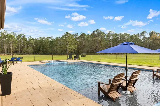 a view of swimming pool with seating area and furniture