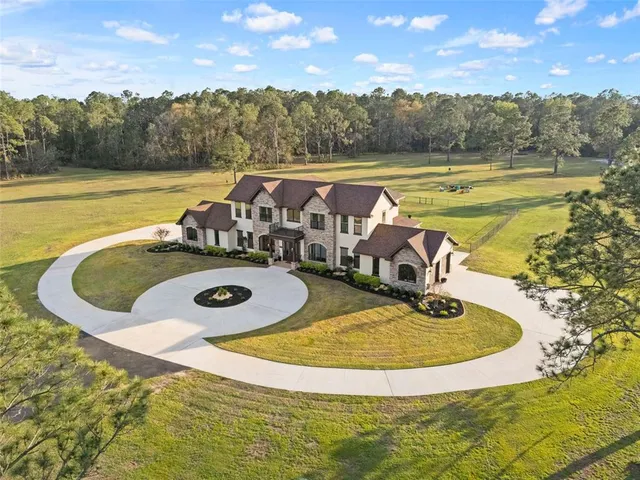 a front view of a house with a garden and trees