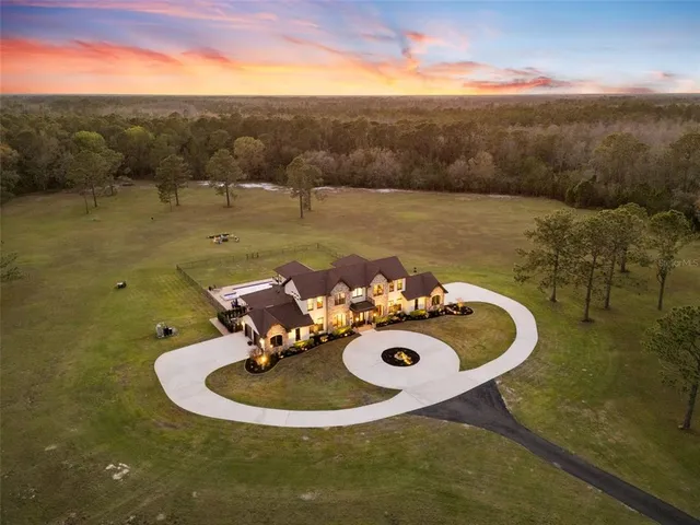 a front view of a house with yard swimming pool and outdoor seating