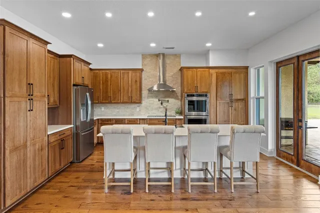 a kitchen with stainless steel appliances kitchen island granite countertop a refrigerator and cabinets