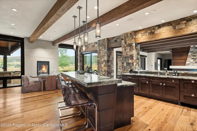 a living room with furniture large windows and wooden floor