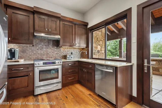 a large kitchen with stainless steel appliances granite countertop a sink and dishwasher with a dining table