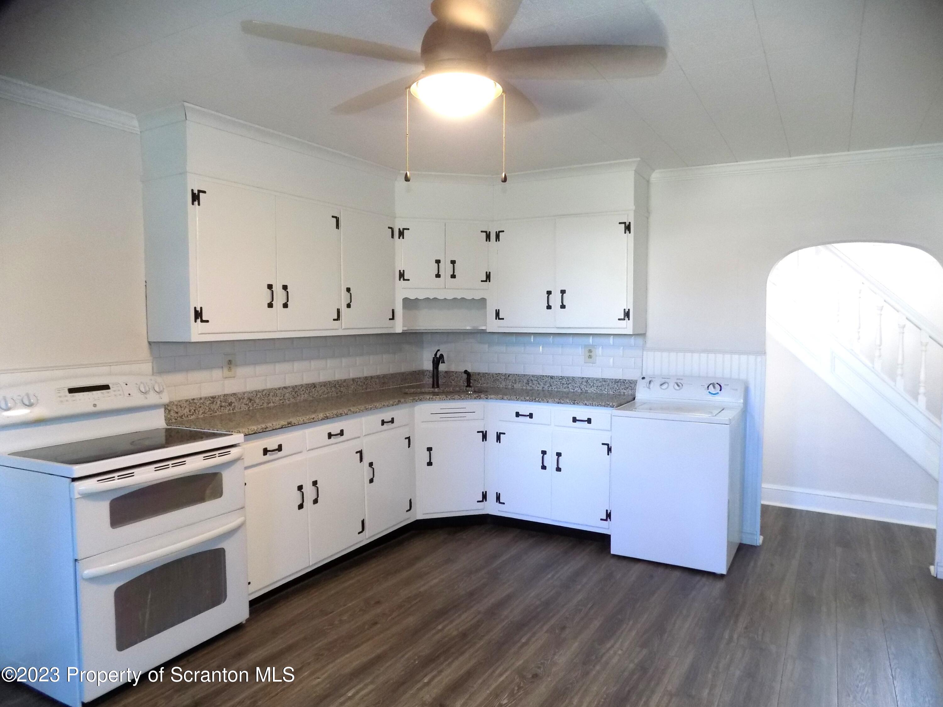 137 Pine Street, Unit 1 Throop, PA 18512 - Photo 3 of 16 a kitchen with granite countertop white cabinets and white appliances