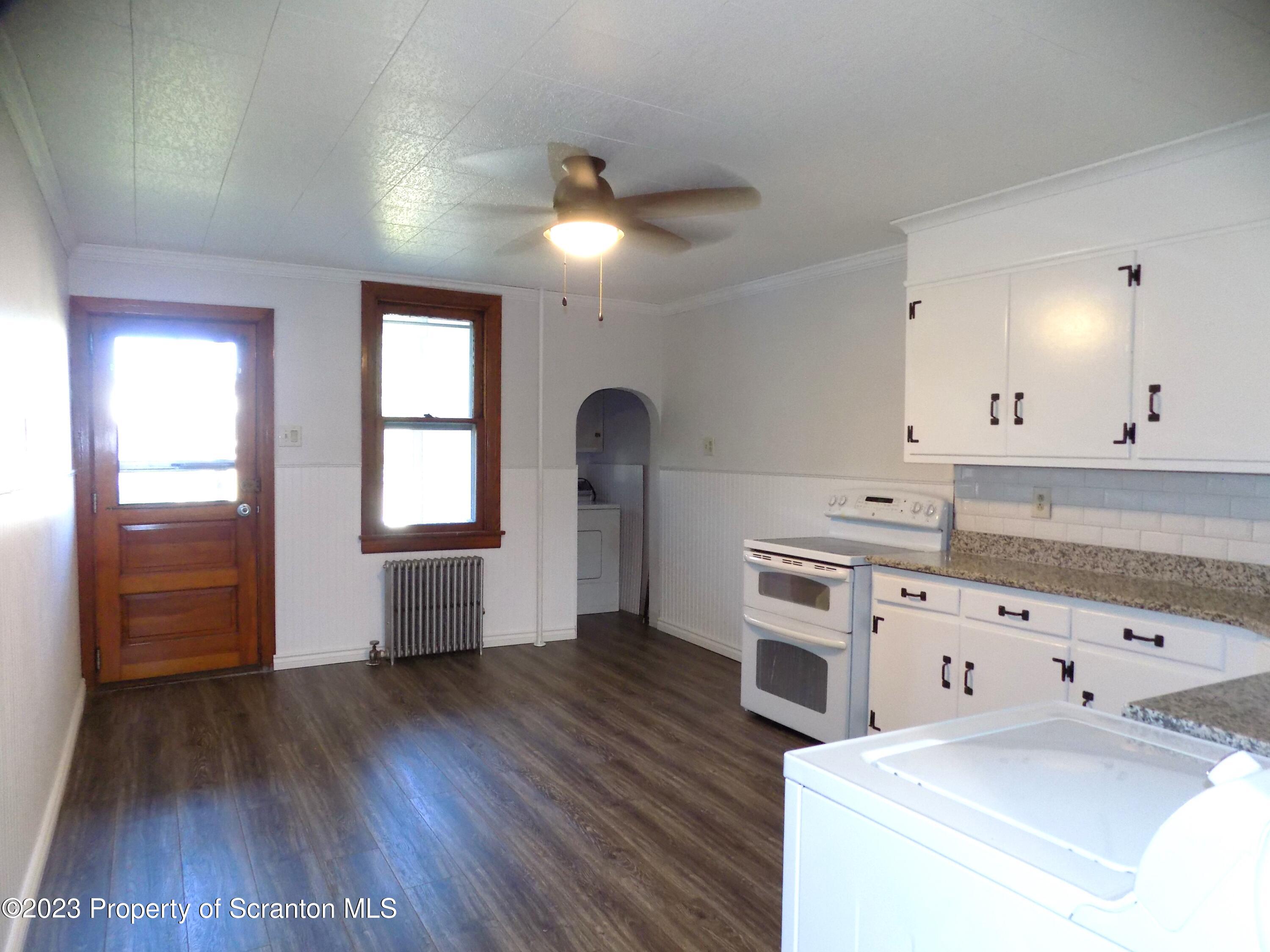 137 Pine Street, Unit 1 Throop, PA 18512 - Photo 4 of 16 a kitchen with granite countertop a stove a sink and a refrigerator