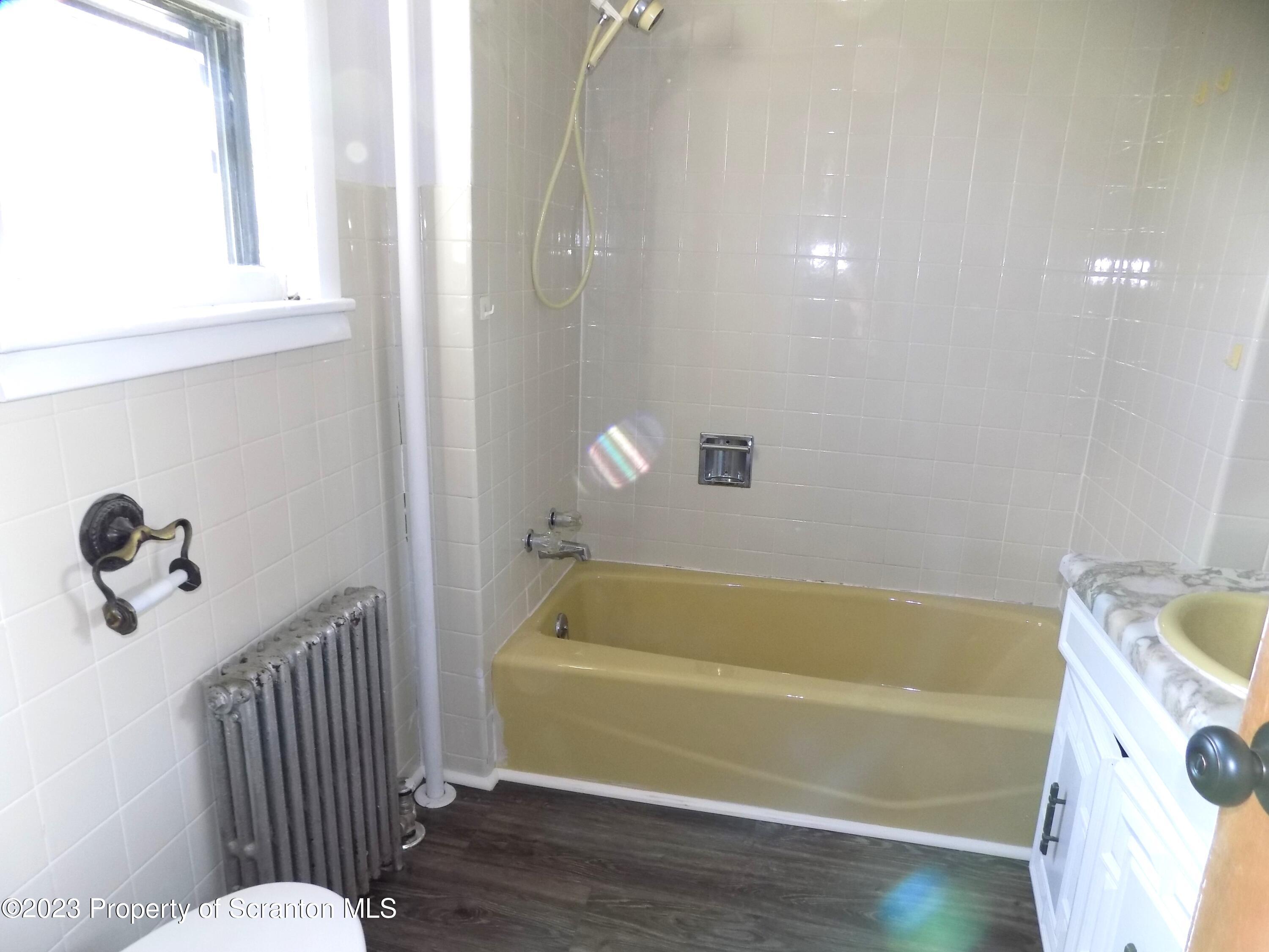137 Pine Street, Unit 1 Throop, PA 18512 - Photo 5 of 16 a bathroom with a tub and a window