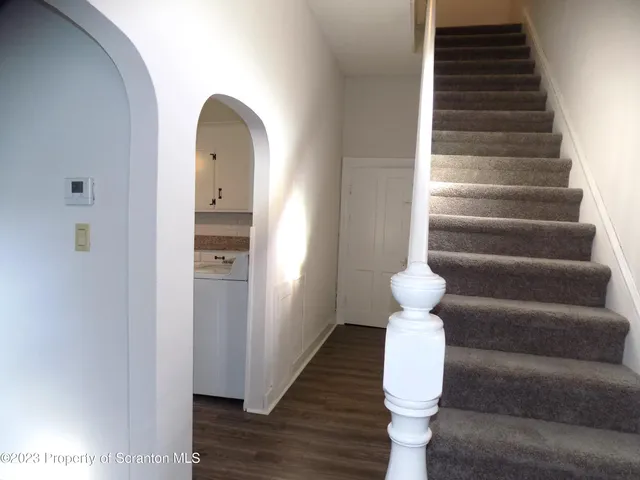 a view of entryway and hall with wooden floor