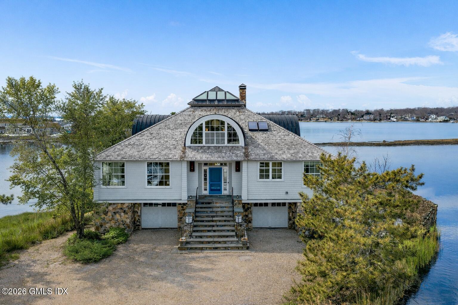 189 Shore Road Old Greenwich, CT 06870 - Photo 3 of 38 a front view of a house with a garden
