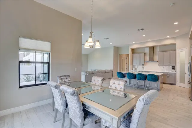 a kitchen with stainless steel appliances granite countertop a sink a stove a refrigerator and island with wooden floor