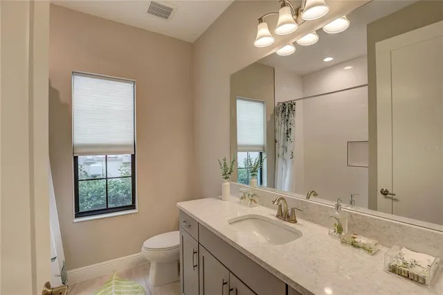 a bathroom with a sink a light fixture and a mirror