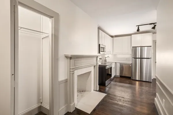 a kitchen with white cabinets and white appliances