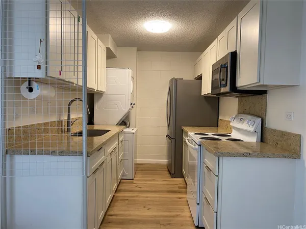 a kitchen with stainless steel appliances granite countertop a refrigerator a stove and a sink
