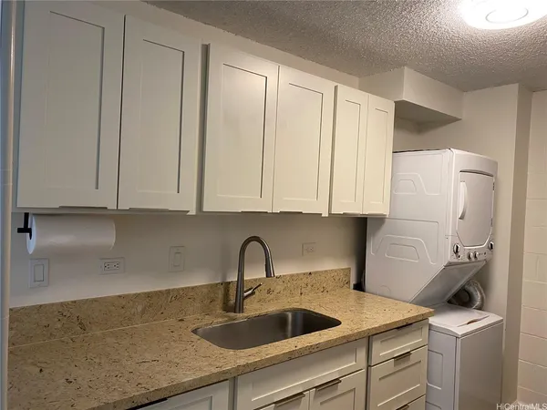 a kitchen with stainless steel appliances granite countertop white cabinets and sink