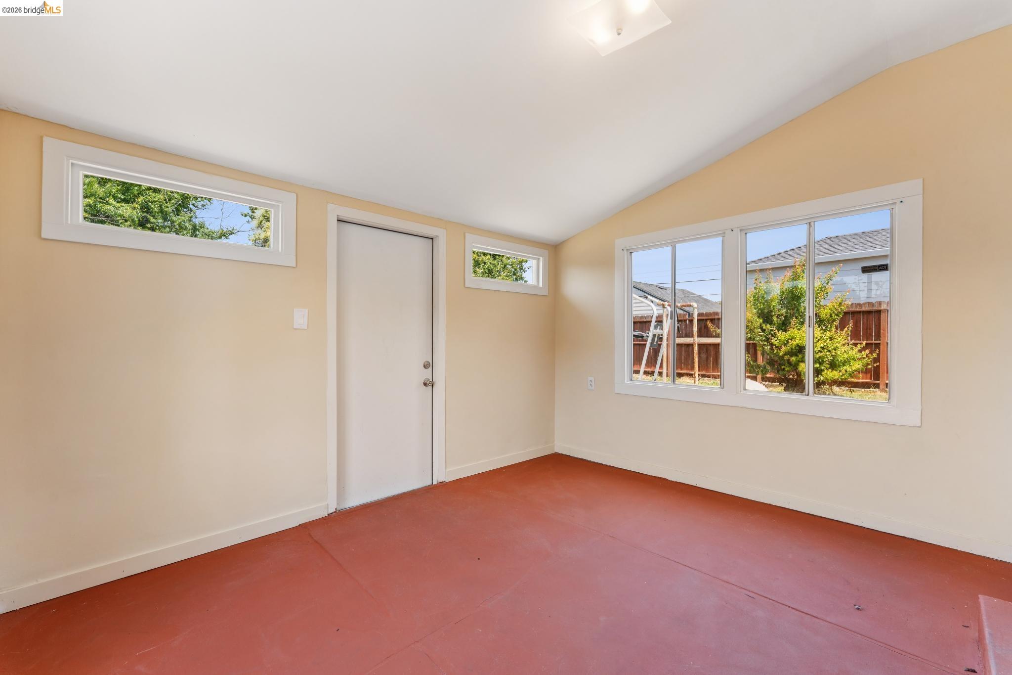 2879 Rheem Avenue Richmond, CA 94804 - Photo 26 of 45 Vaulted ceiling room featuring light beige walls and red-toned flooring