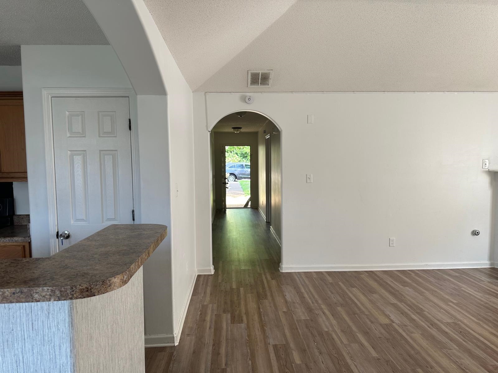 8857 Macon Road Memphis, TN 38018 - Photo 8 of 13 Vaulted ceiling with a central arched entryway and wood-finish flooring