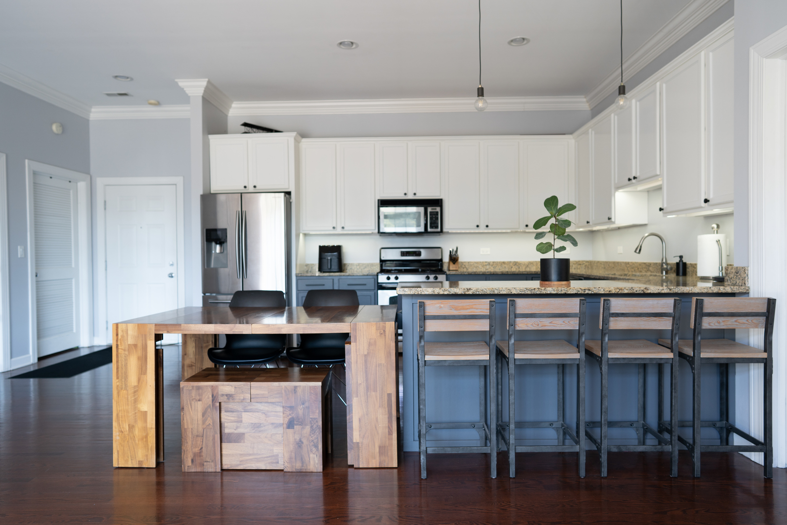 6421 West Touhy Avenue, Unit 4B Chicago, IL 60646 - Photo 7 of 24 a kitchen with granite countertop a table chairs microwave and cabinets