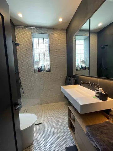 a bathroom with a sink a toilet and mirror