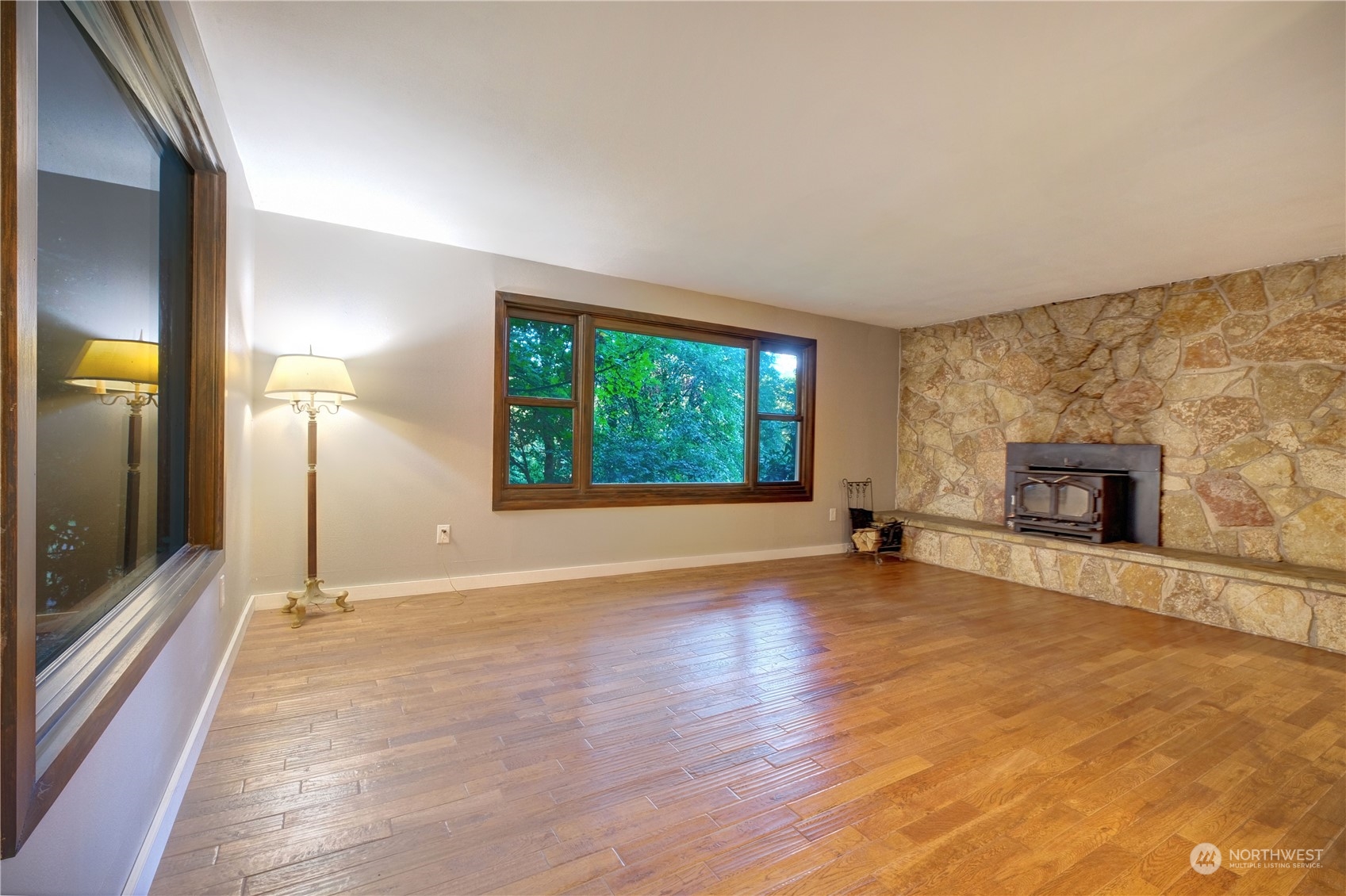 17802 Southeast Jones Road Renton, WA 98058 - Photo 12 of 38 an empty room with floor to ceiling window and fireplace