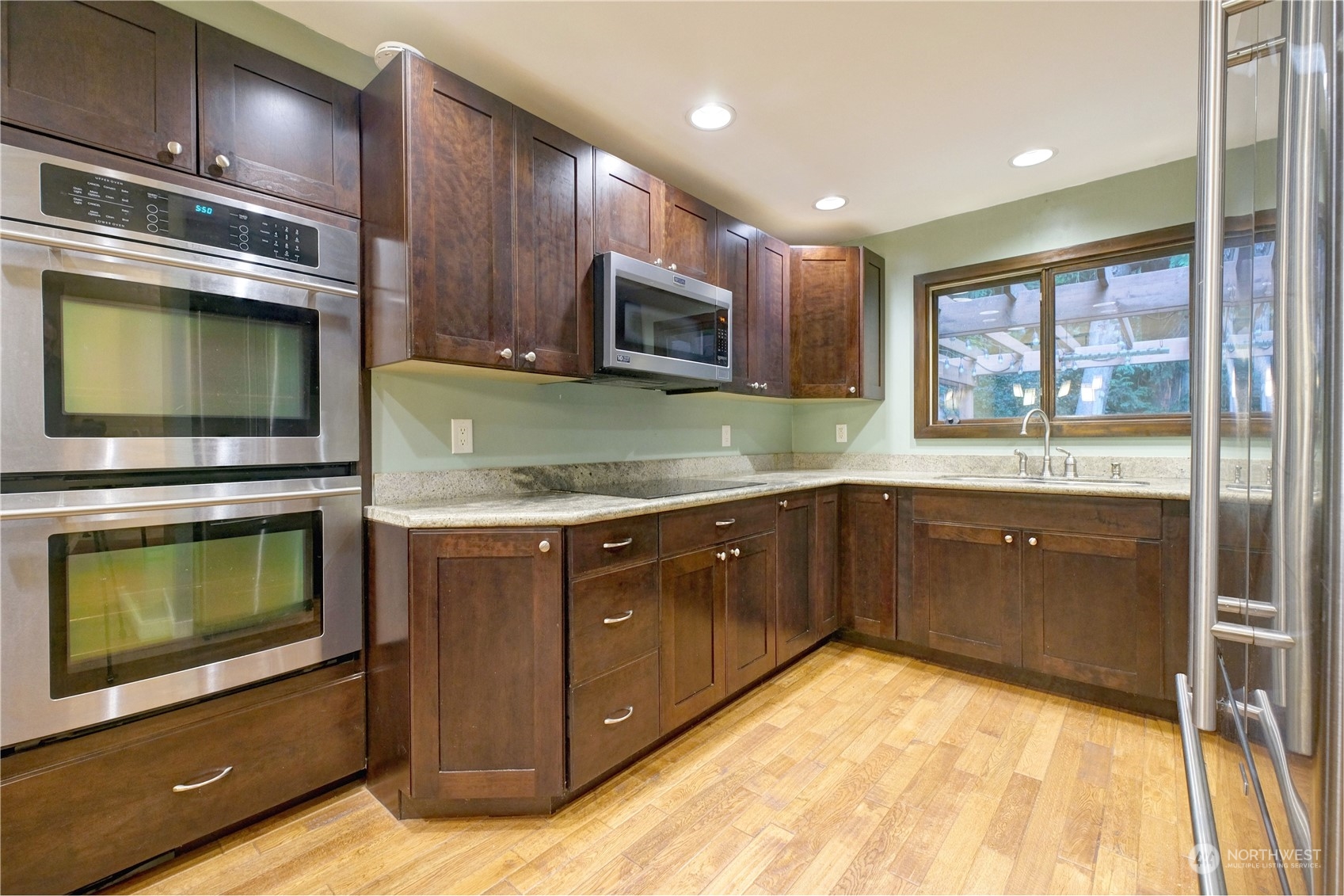 17802 Southeast Jones Road Renton, WA 98058 - Photo 7 of 38 a kitchen with stainless steel appliances granite countertop a stove microwave and sink