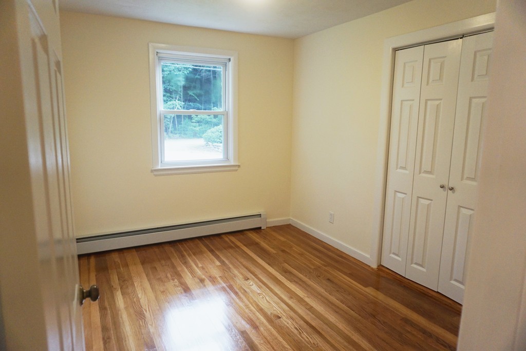 115 Harvard Road Littleton, MA 01460 - Photo 7 of 20 a view of an empty room with wooden floor and a window