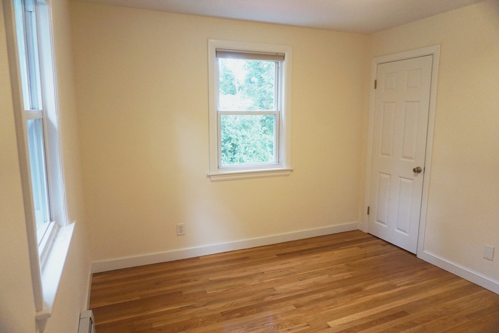 115 Harvard Road Littleton, MA 01460 - Photo 8 of 20 a view of an empty room with wooden floor and a window