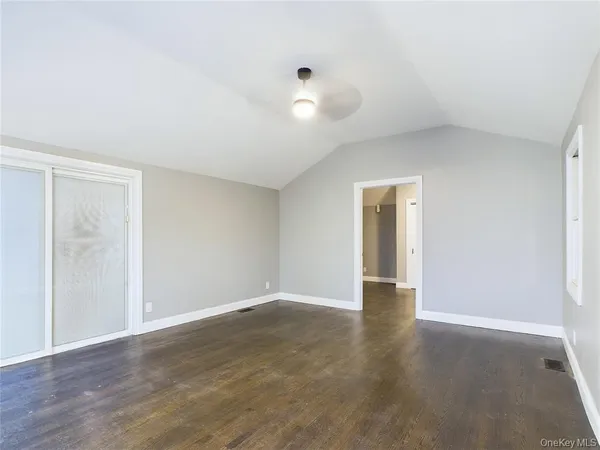 a view of an empty room with wooden floor and closet
