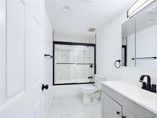 a bathroom with a sink toilet a mirror and shower