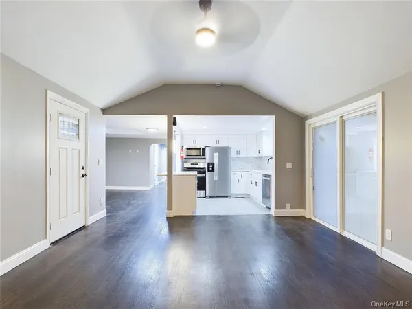a view of a big room with wooden floor windows and kitchen view