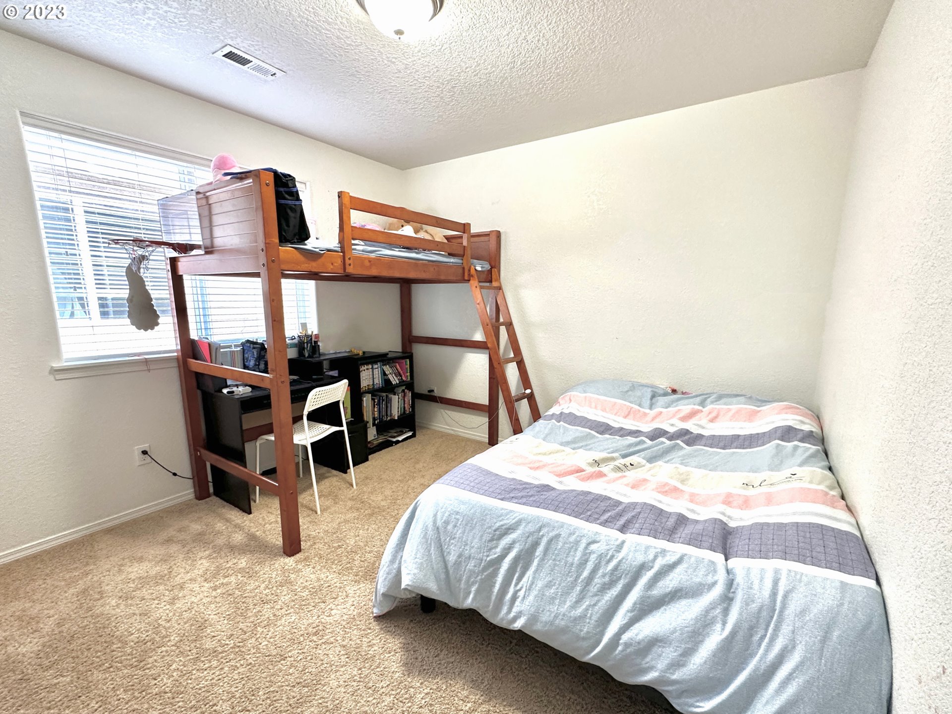 12428 Southeast Center Street Portland, OR 97236 - Photo 12 of 17 a bed sitting in a bedroom next to a window