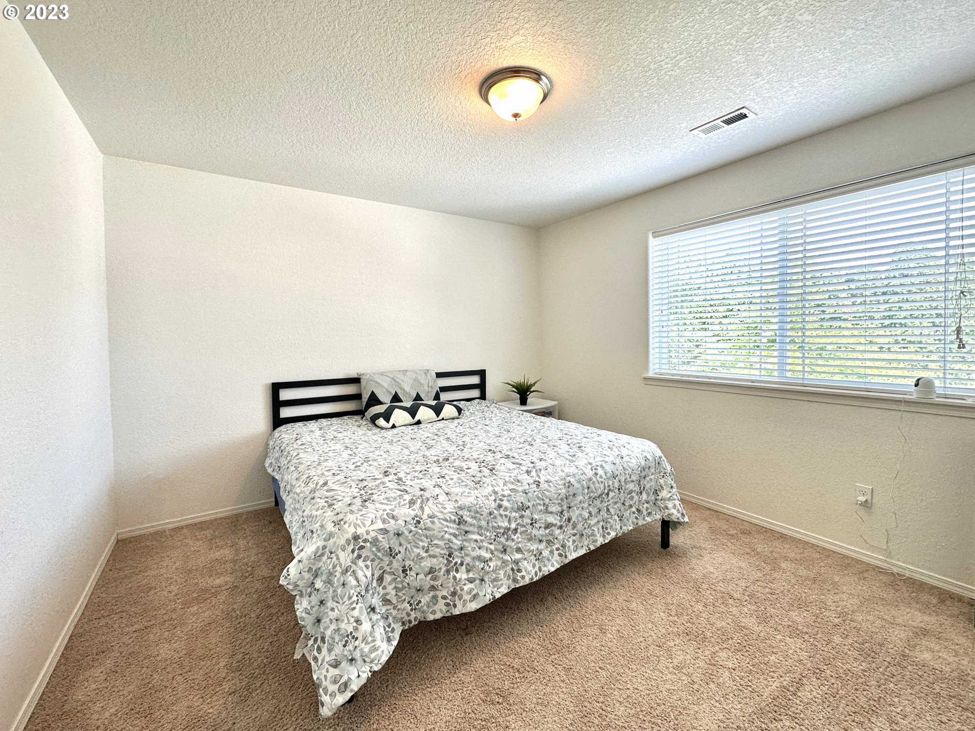 12428 Southeast Center Street Portland, OR 97236 - Photo 14 of 17 a bed sitting in a room next to a window