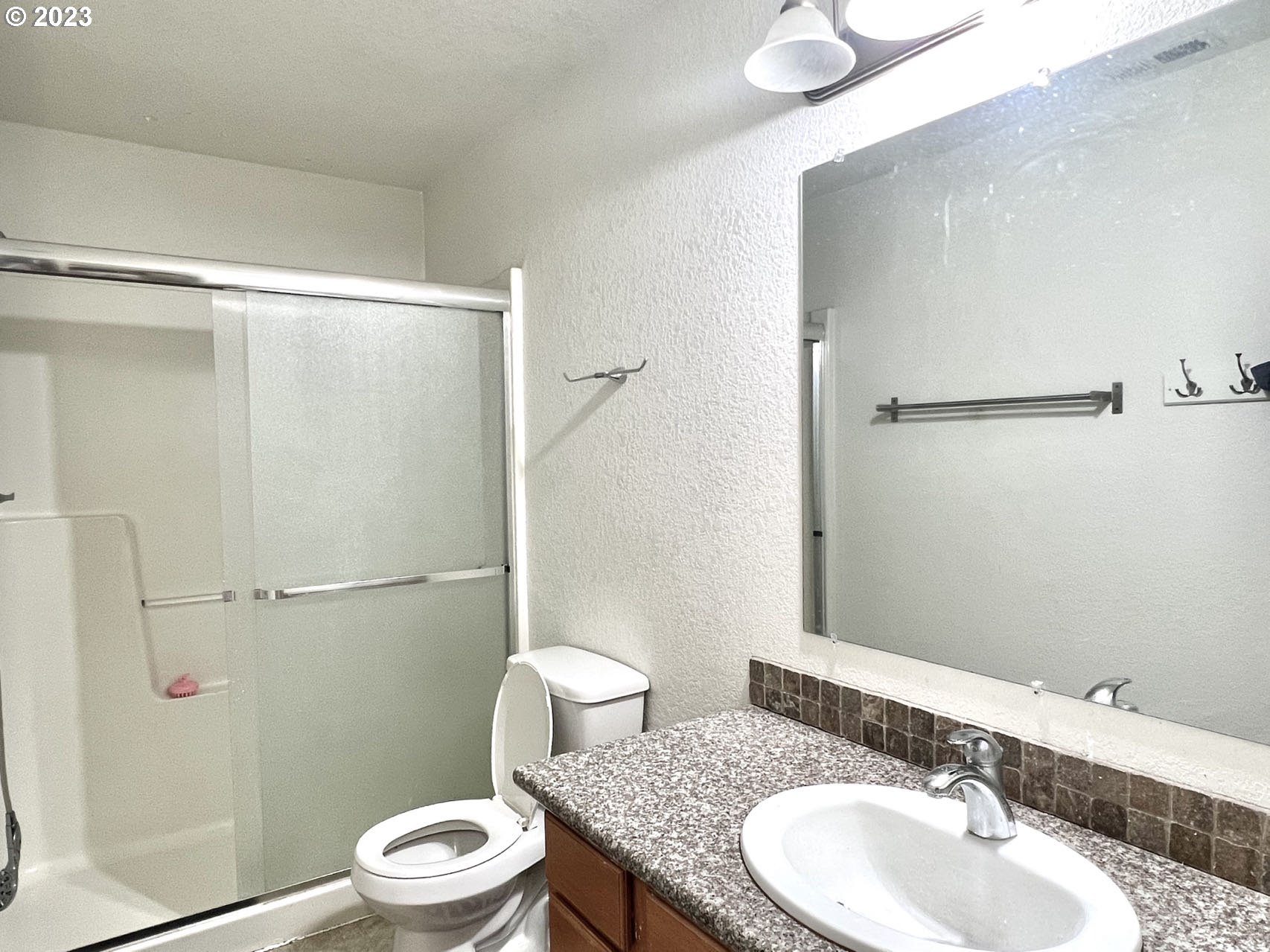 12428 Southeast Center Street Portland, OR 97236 - Photo 15 of 17 a bathroom with a granite countertop sink toilet and shower