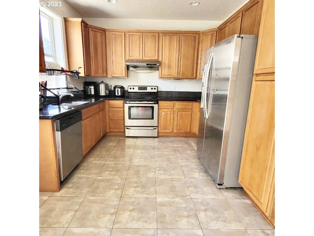 12428 Southeast Center Street Portland, OR 97236 - Photo 6 of 17 a kitchen with stainless steel appliances granite countertop a refrigerator and a stove