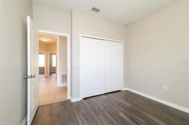 an empty room with wooden floor and a bathroom