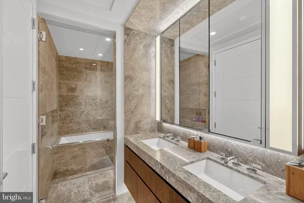 a bathroom with a granite countertop sink mirror and shower