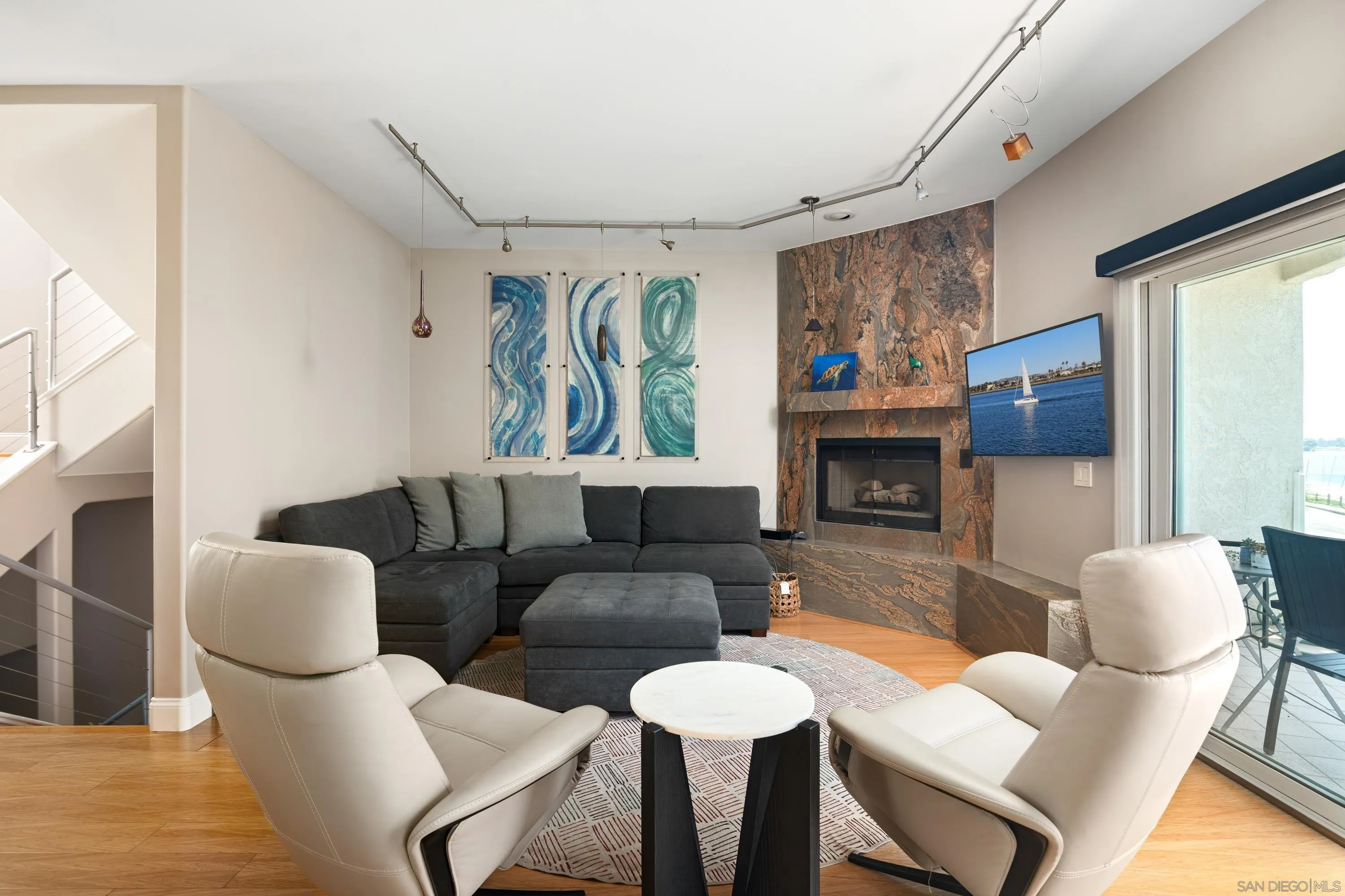 3701 Riviera Drive, Unit 11 Pacific Beach, CA 92109 - Photo 11 of 32 a living room with furniture a flat screen tv and a fireplace