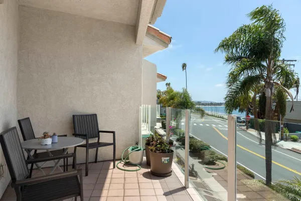 a view of a balcony with chairs and a potted plant