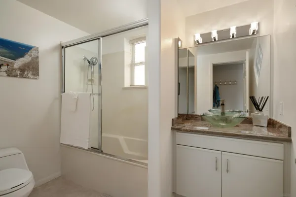 a bathroom with a granite countertop sink toilet and mirror