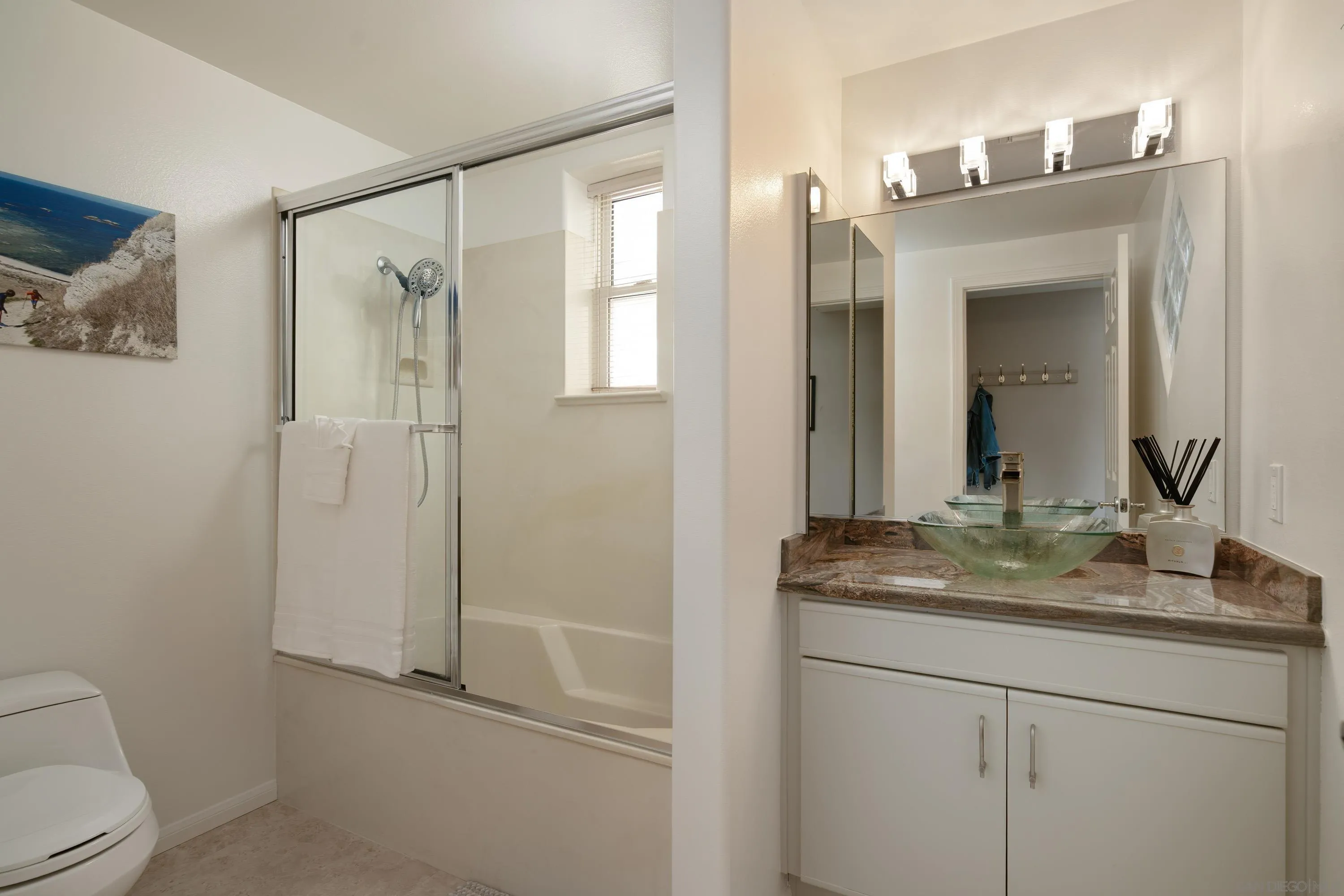 3701 Riviera Drive, Unit 11 Pacific Beach, CA 92109 - Photo 23 of 32 a bathroom with a granite countertop sink toilet and mirror