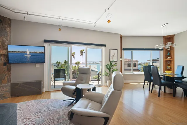 a living room with furniture wooden floor and kitchen view